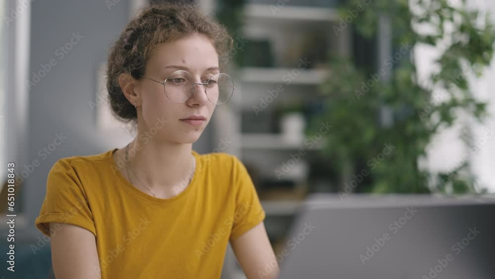Young smiling woman worker, an online work from home, searches for information on laptop and thoughtfully reads everything what browsing Young smiling woman worker, an online work from home, searches for information on laptop and thoughtfully reads everything what browsing