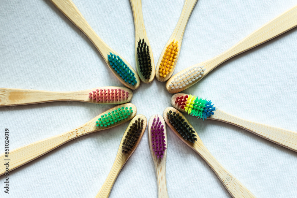 multicolored toothbrushes with a bamboo handle lie on a white background. oral care multicolored toothbrushes with a bamboo handle lie on a white background. oral care