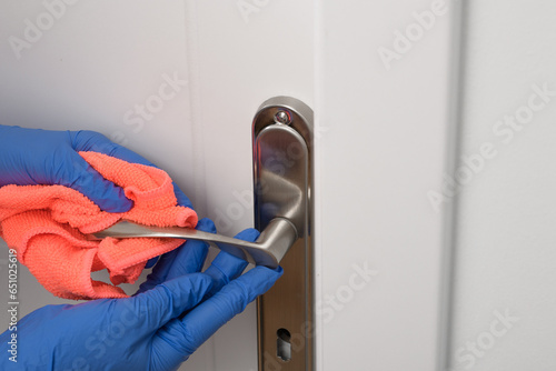 Klamka od drzwi łazienki wycierana ściereczką, dezynfekcja bakterii