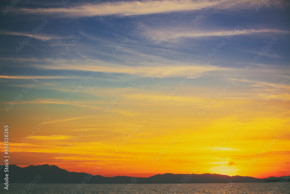 Seascape with mountains on the horizon at sunset. Rockies in the evening. View of Mount Olympus on the horizon. Beautiful nature of Greece