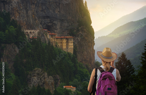 Tourist woman watches Sümela Monastery at sunset time. Sumela Monastery is one of the best tourist travel destinations in the Black Sea region of Turkey. Macka town, Trabzon , Turkey 