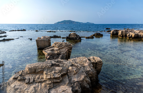 A landscape with a rocky coast in the evening