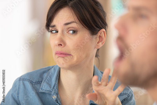 woman makes disgusted expression beside man with open mouth
