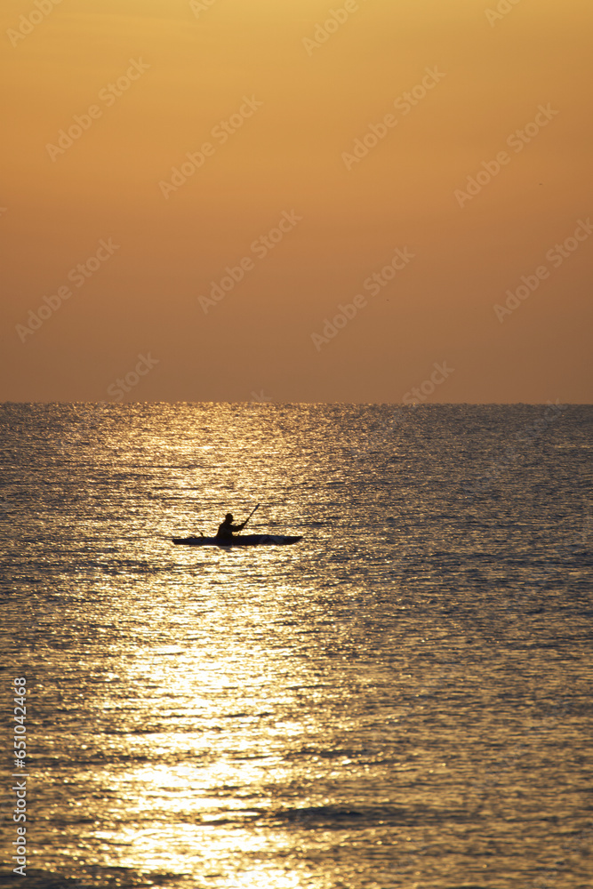 Fototapeta premium Canoe fisherman at sea at dawn