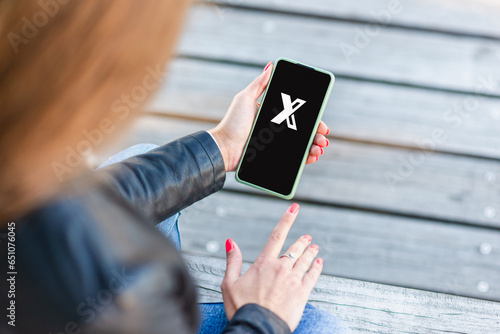 Canvas Print Person holding mobile phone with a letter X on the screen