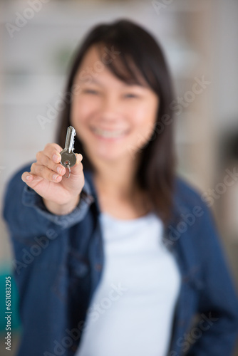 young asian woman showing a key