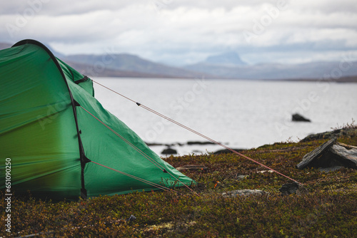 Green Hilleberg tent by a lake in the swedish mountains