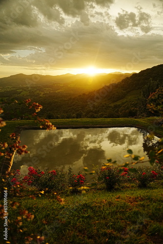 amanecer desde la montaña con un estanque y flores, paisaje embaucador 