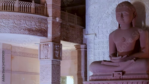 isolated red stone jain god holy statue in meditation from different angle video is taken at Shri Digamber Jain Gyanoday Tirth Kshetra, Nareli Jain Mandir, Ajmer, Rajasthan, India. photo