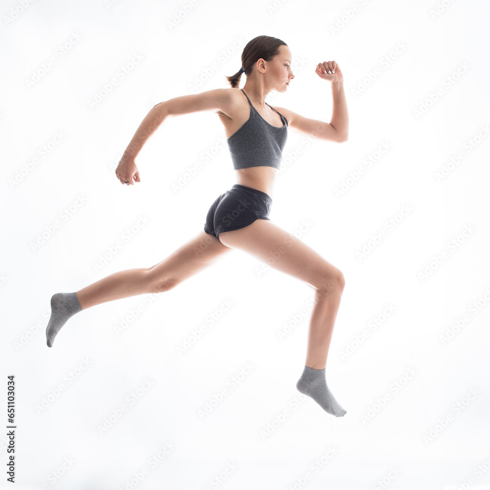 Teen beautiful girl athlete running against white background