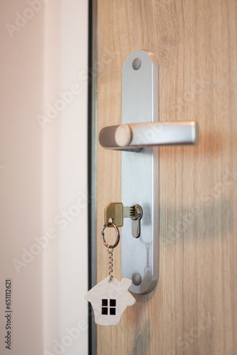 door handle and key in the keyhole with house pendant. Ideal photo for real estate and financial advice propagation.