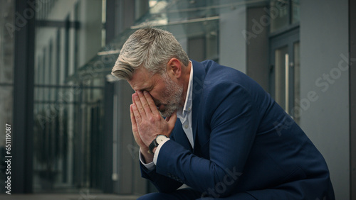 Pensive Caucasian middle-aged old man feeling headache eyes strain discomfort thinking thoughtful unwell senior businessman worried problem migraine worry failure mature business male in city outdoors