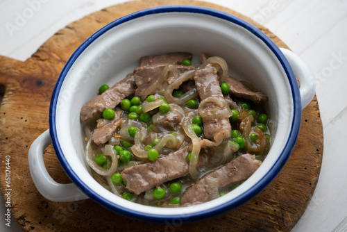 Beef strips cooked with onion and peas.