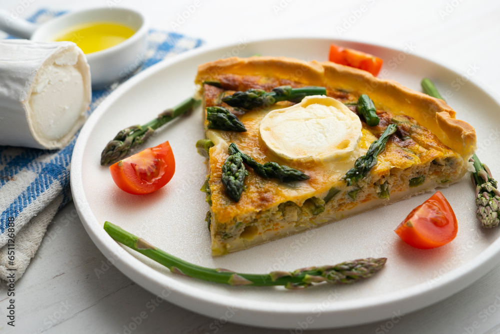 French style quiche with green asparagus, eggs, and slices of goat cheese.