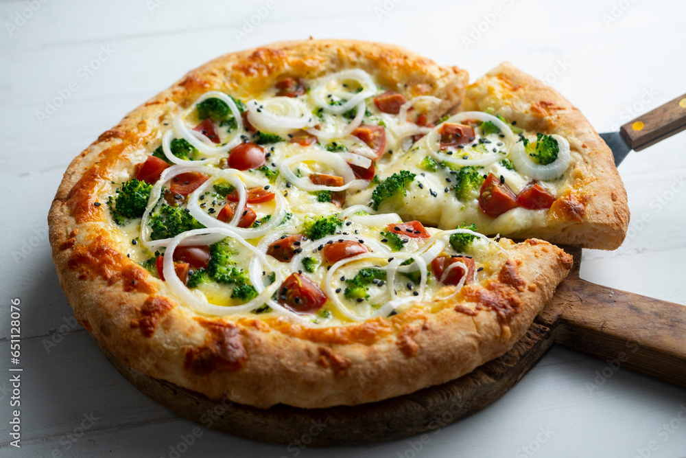 Neapolitan pizza with cheese, onion, broccoli and cherry tomatoes.