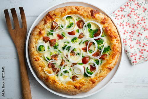 Neapolitan pizza with cheese, onion, broccoli and cherry tomatoes.