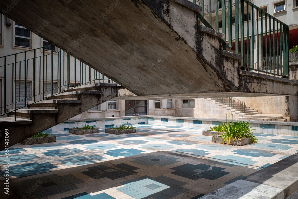 Brutalist stairs over a geometric patterned pool with planters