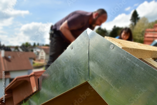 Montiertes Ortgangblech durch den Dachdecker am äusseren Sparren der Giebelseite des Steildachs eines Holzhauses photo