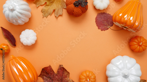 Set of ceramic pumpkins and candles on orange background. Fall decor, interior decoration. Flat lay, top view, copy space