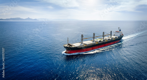 Obraz na płótnie Aerial view of a bulk carrier cargo vessel traveling with high speed over blue sea with copy space as a concept for import and export industry w salonie