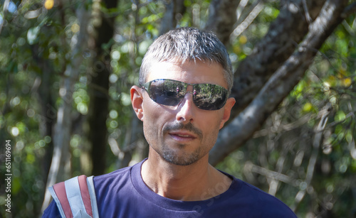 Portrait of a happy caucasian man during a hike in the forest