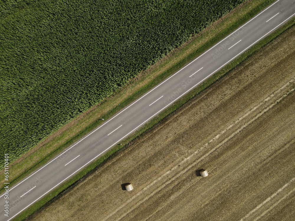 Drone view of a road between country fields in the countryside 