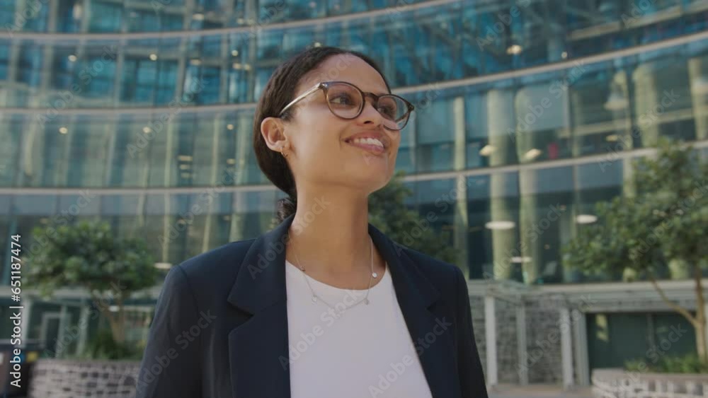 Young multiracial woman with eyeglasses looking away outside office building Young multiracial woman with eyeglasses looking away outside office building