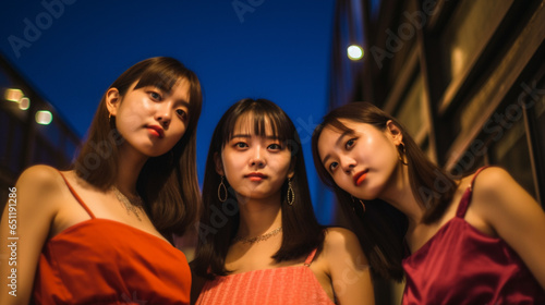 three young adult Asian women in a city on a side street, typical everyday life after work in their free time