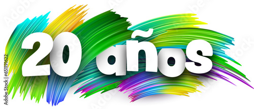 20 years at spanish paper word sign with colorful spectrum paint brush strokes over white.