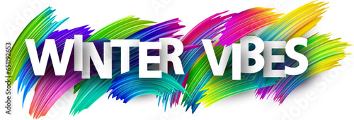 Winter vibes paper word sign with colorful spectrum paint brush strokes over white.