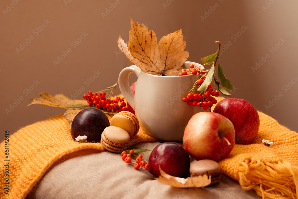 cup of hot tea with macaroons, apples and plums, and autumn leaves, on wooden table cup of hot tea with macaroons, apples and plums, and autumn leaves, on wooden table
