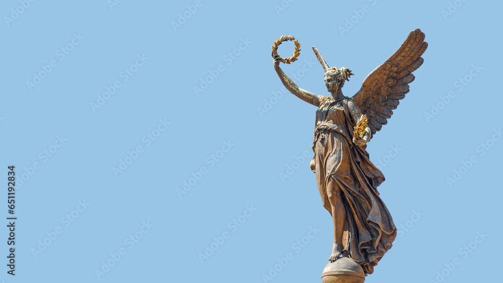 Obraz premium Prague, Czech Republic, Banner with Statue of beautiful angel at the top of column on the Cechuv Most Bridge in Prague, Czech Republic, at blue sky background with copy space