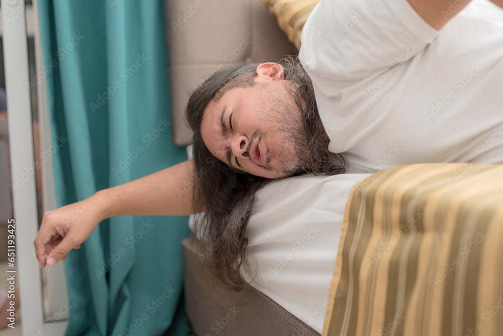 A man feeling excruciating stomach pain while lying prone on the edge