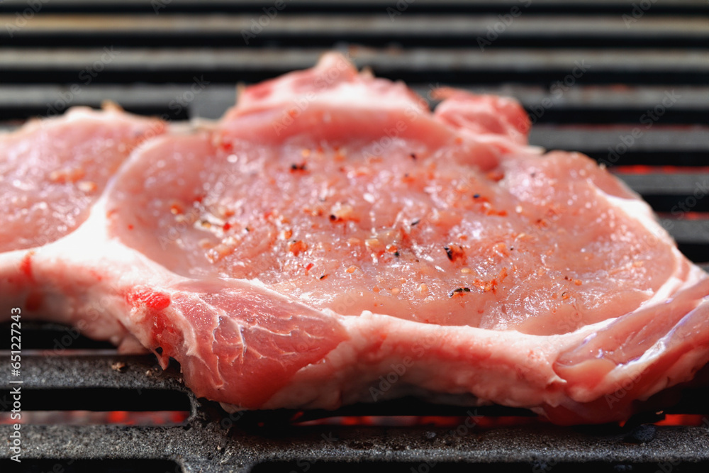 A delicious steak is prepared on the grill grate. Grilled beef fillet. Background with place for text A delicious steak is prepared on the grill grate. Grilled beef fillet. Background with place for text