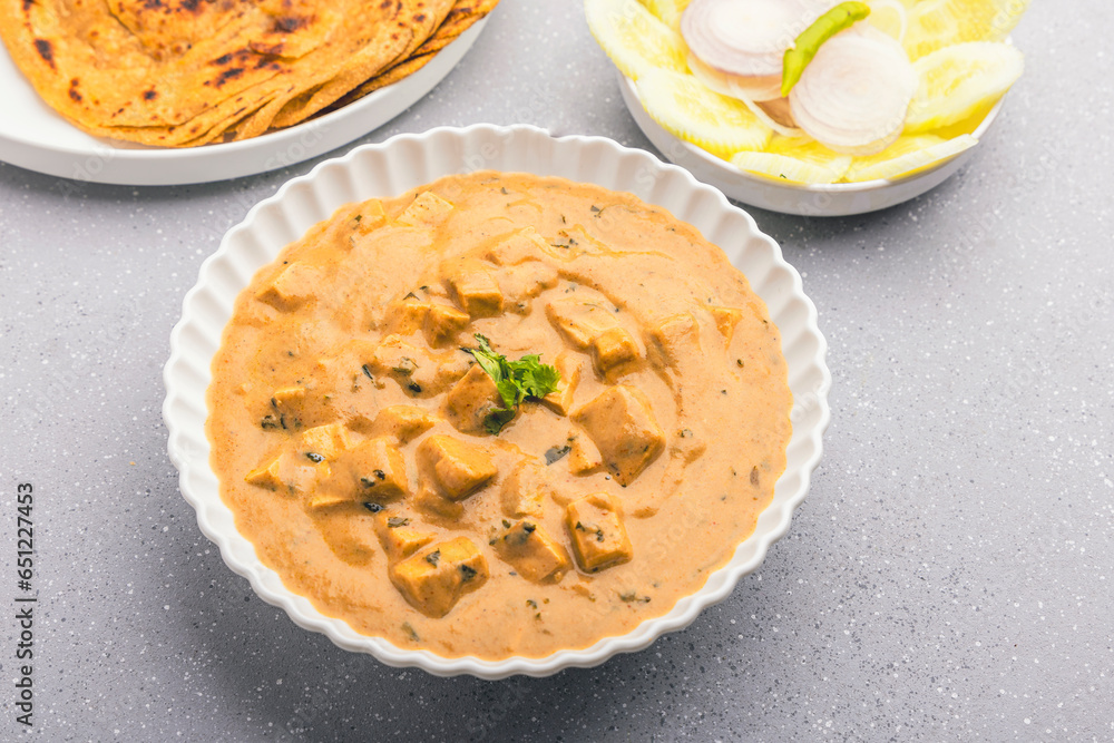 Delicious and creamy shahi paneer on a round plate, served hot with roti and green salad Delicious and creamy shahi paneer on a round plate, served hot with roti and green salad