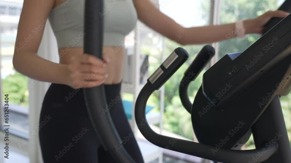 Young Woman Workout with Elliptical Machine in Gym Young Woman Workout with Elliptical Machine in Gym