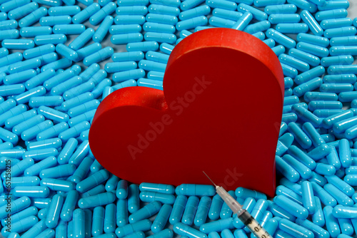 heart shape and medicine capsules representing heart problems and treatment