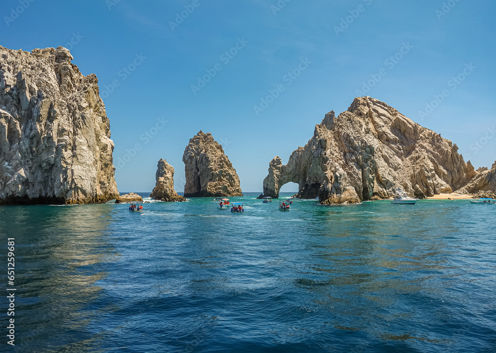 Mexico, Cabo San Lucas - July 16, 2023: El Arco rocky arch at Reserva de Lobos Marinos. Passage from ocean to bay with plenty of small sightseeing boats up front