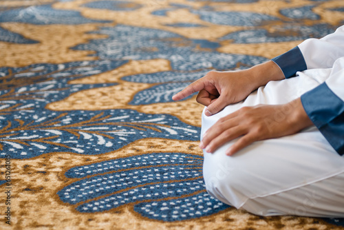 Muslim men praying in Tashahhud posture