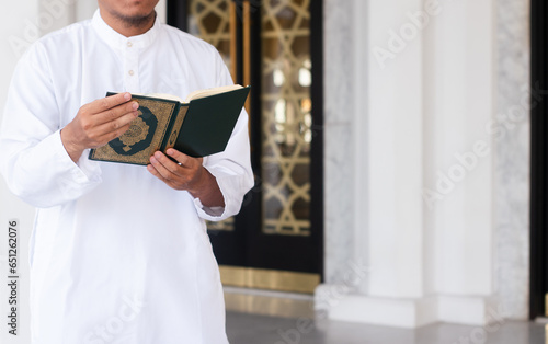 Holy Quran in Hand. Muslim man holding Quran