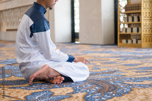 Muslim men praying in Tashahhud posture