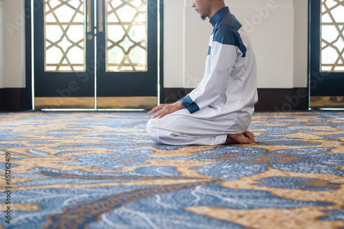 Muslim men praying in Tashahhud posture