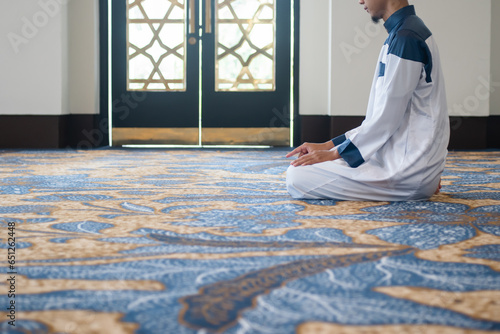 Muslim men praying in Tashahhud posture photo