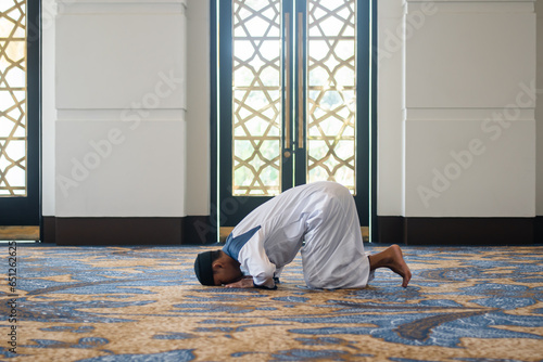 Muslim men praying in sujud or prostration posture