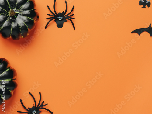Halloween design copy space, pumpkin, spiders and bats on a background board, spooky Halloween party card © eman