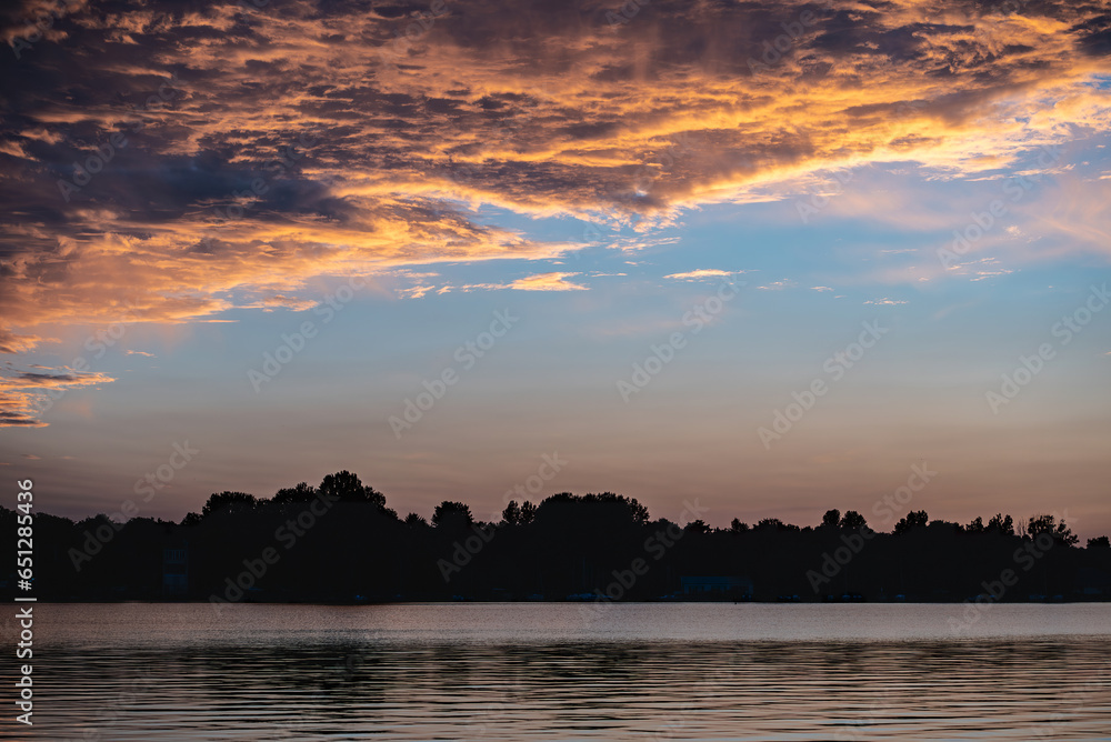 beautiful sunset with purple and pink sky, gloden hour over lake or river
