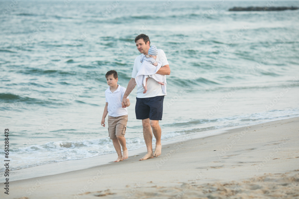 Father and child playing on tropical beach at sunset. Family summer vacation at sea resort. Dad playing with kids on sunny evening at ocean shore. Travel with children. Parent love