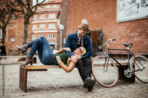 Fototapeta Naklejka Na Ścianę i Meble -  Middle aged Caucasian couple relaxing on the bench after riding a bicycle together in the city