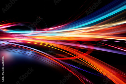 Abstract image of bright colored light streaks of red  orange and blue in motion on a black background