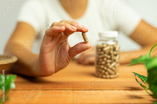 Capsule held in hand, dietary supplement of plant origin, ashwagandha, natural laboratory